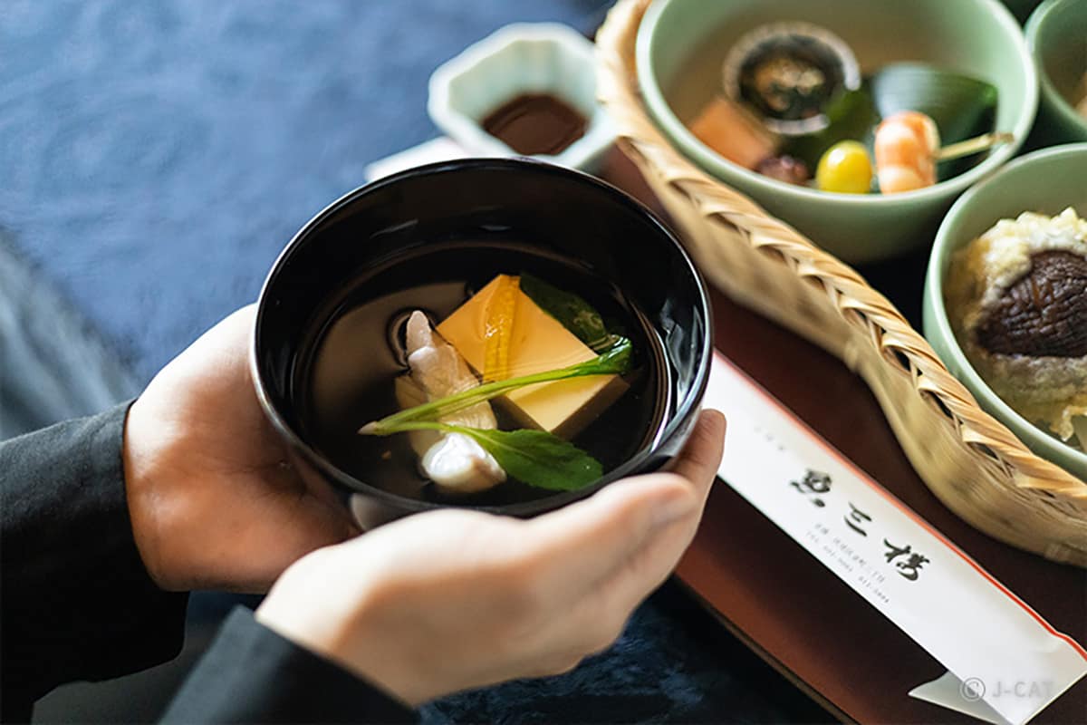 Luxury Experiences in Kyoto Man holding a bowl of Japanese soup