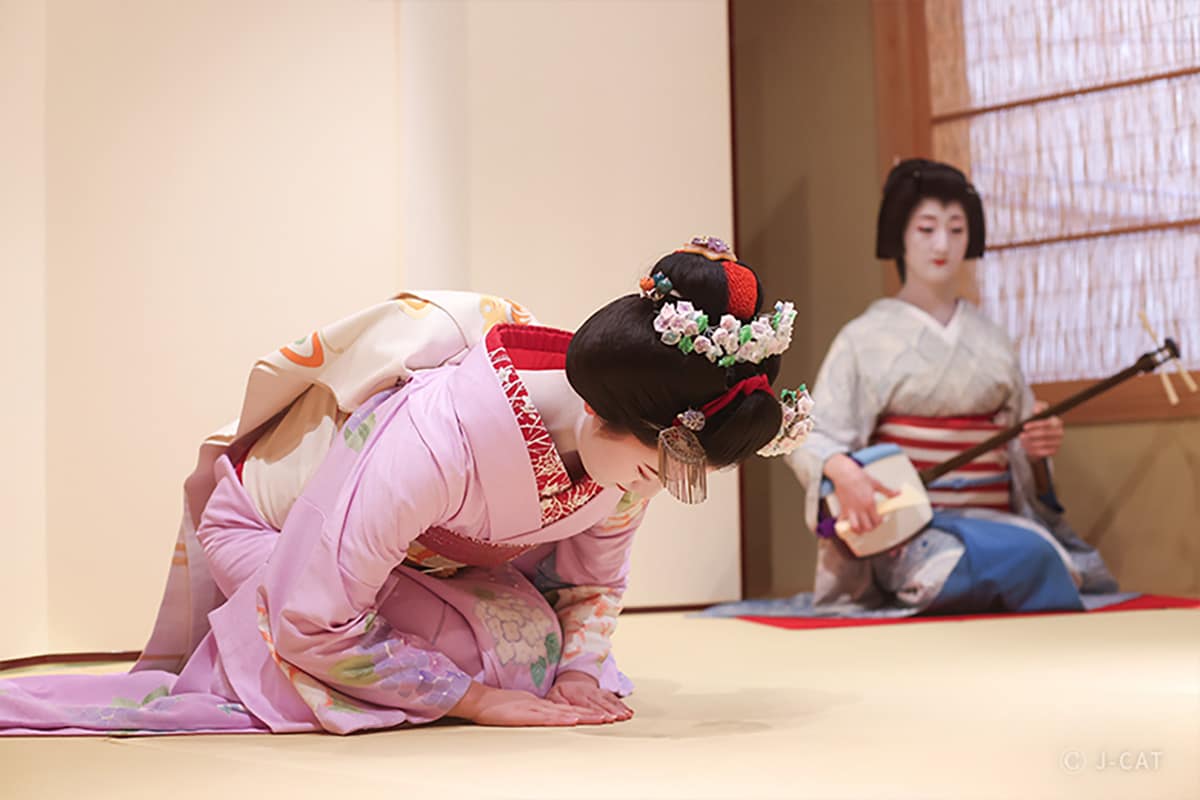 Luxury Experiences in Kyoto One geisha bowing and another geisha playing an instrument