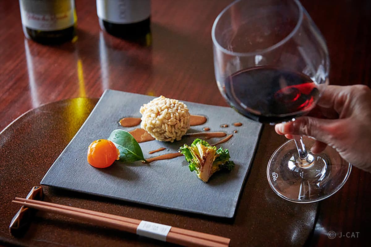 Luxury Experiences in Tokyo Beautifully plated Japanese dishes with a glass of red wine