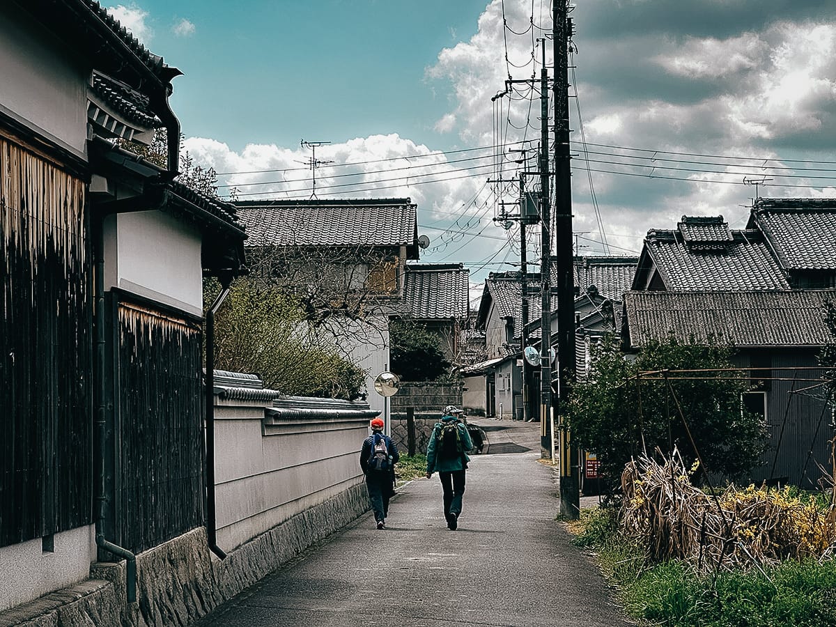 Yamanobe-no-michi Trail Two Japanese hikers waling through a small town