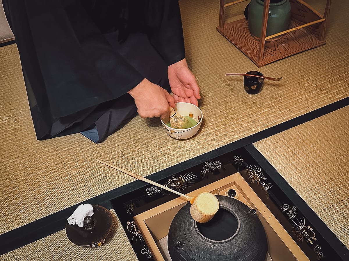 The Japanese Tea Ceremony Japanese man whisking green tea